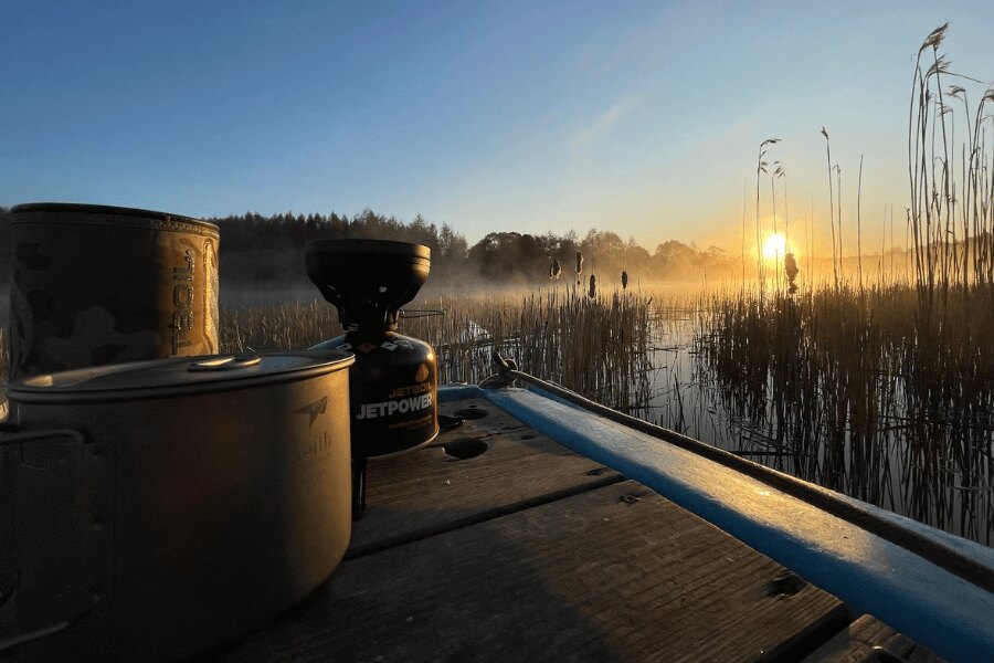 Varič Jetboil a riad Keith pri vode v Estónsku pri východe slnka