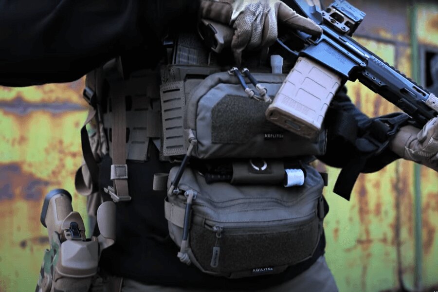 Muž s Chest Rig Reaper™ Agilite Gear<sup>&reg;</sup> osadeným sumkami a s dlhou zbraňou. Zdroj: Rigad - video