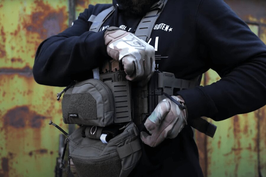 Muž s Chest Rig Reaper™ Agilite Gear<sup>&reg;</sup> osadeným sumkami upravuje nastavenie. Zdroj: Rigad - video